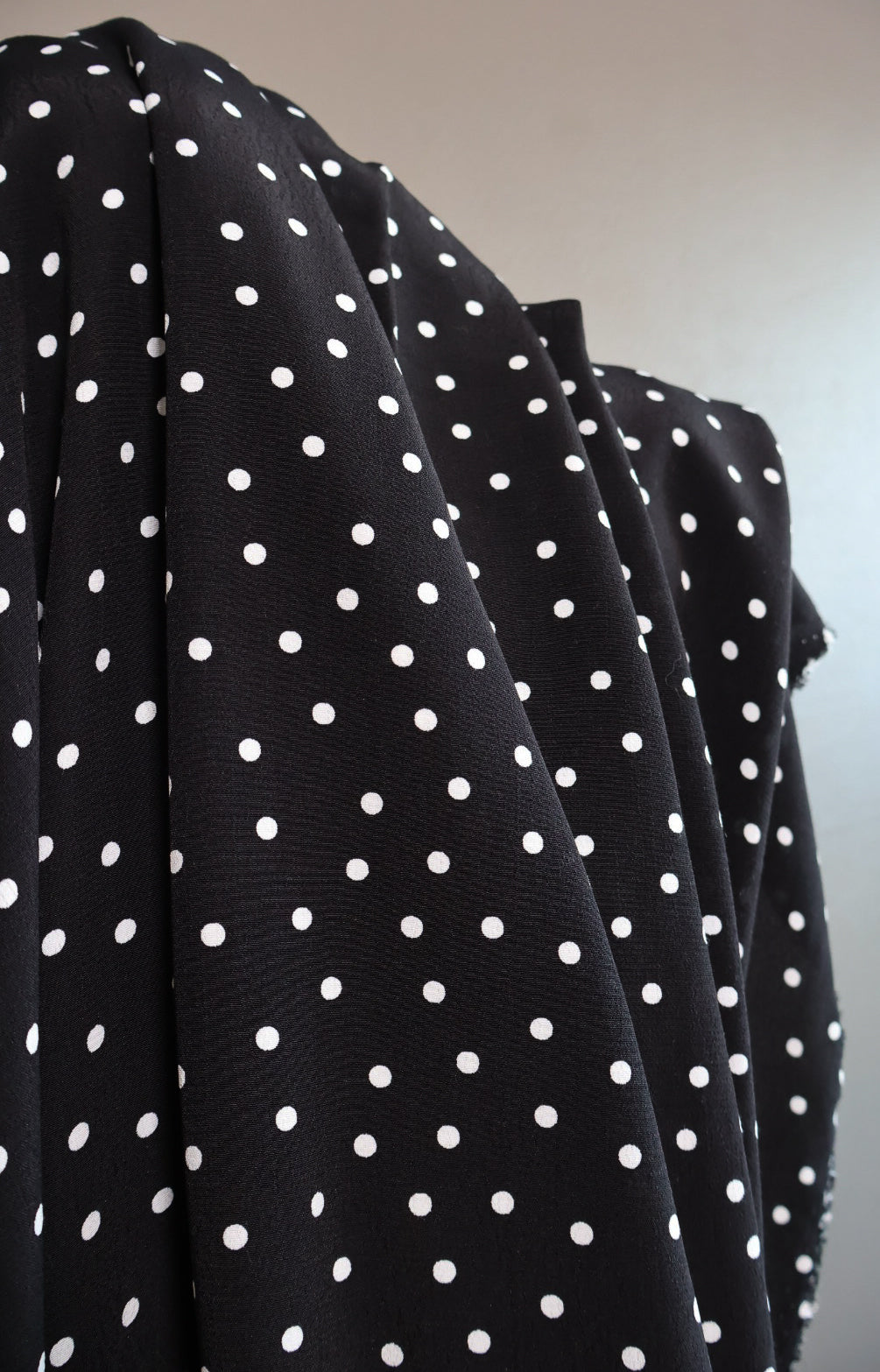 Viskose Crêpe Polka Dot sort med hvite prikker